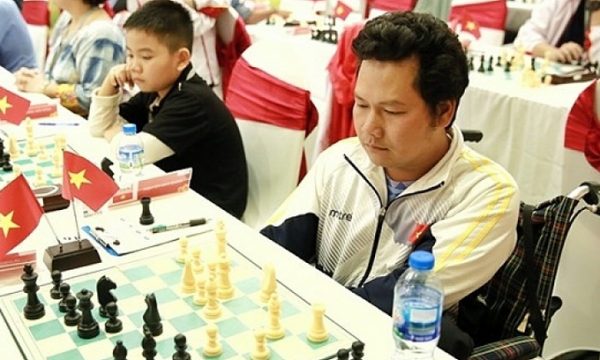 Kỳ thủ khuyết tật Việt Nam Văn Quân (phải) thi đấu tại giải cờ vua quốc tế HDBank 2018, ở Hà Nội.